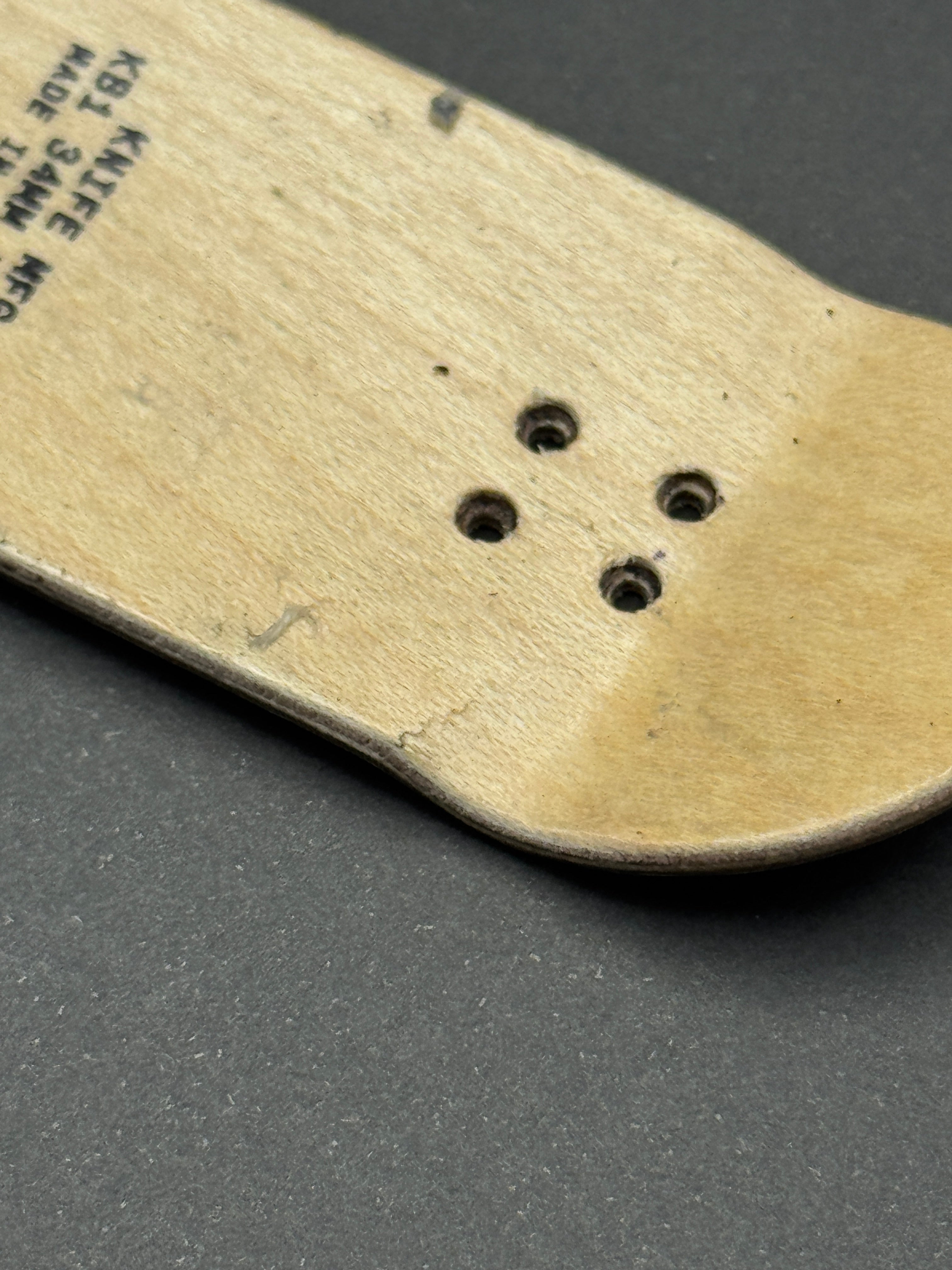 Knife Mfg. Co. 34mm KB1 - Skated - bottom close-up showing cosmetic top ply cracks