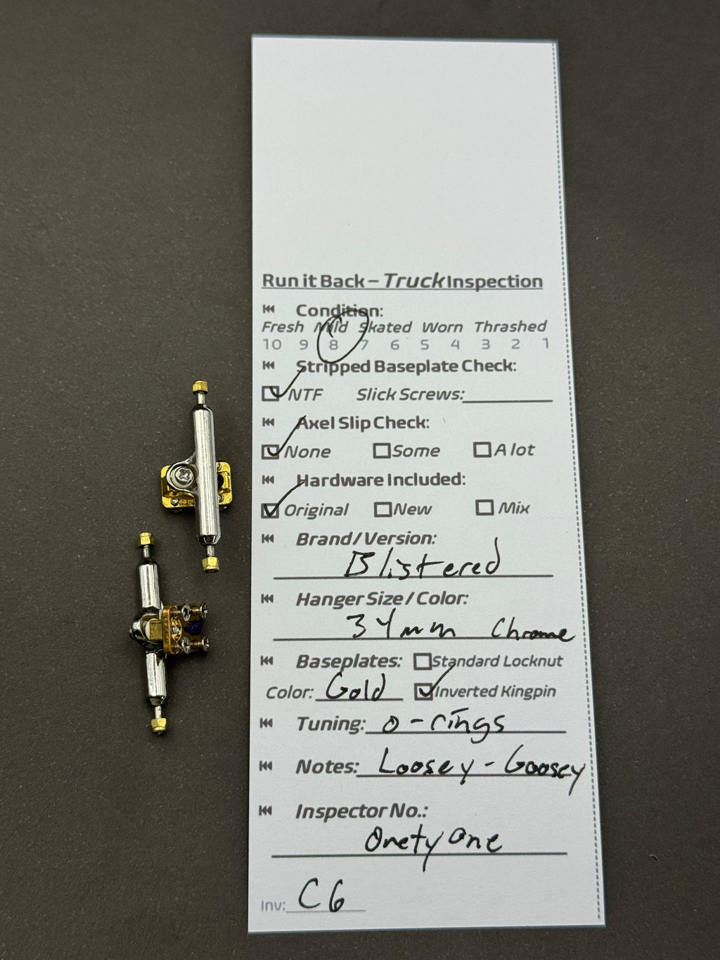 Blistered 34mm Chrome / Gold trucks – inspection card